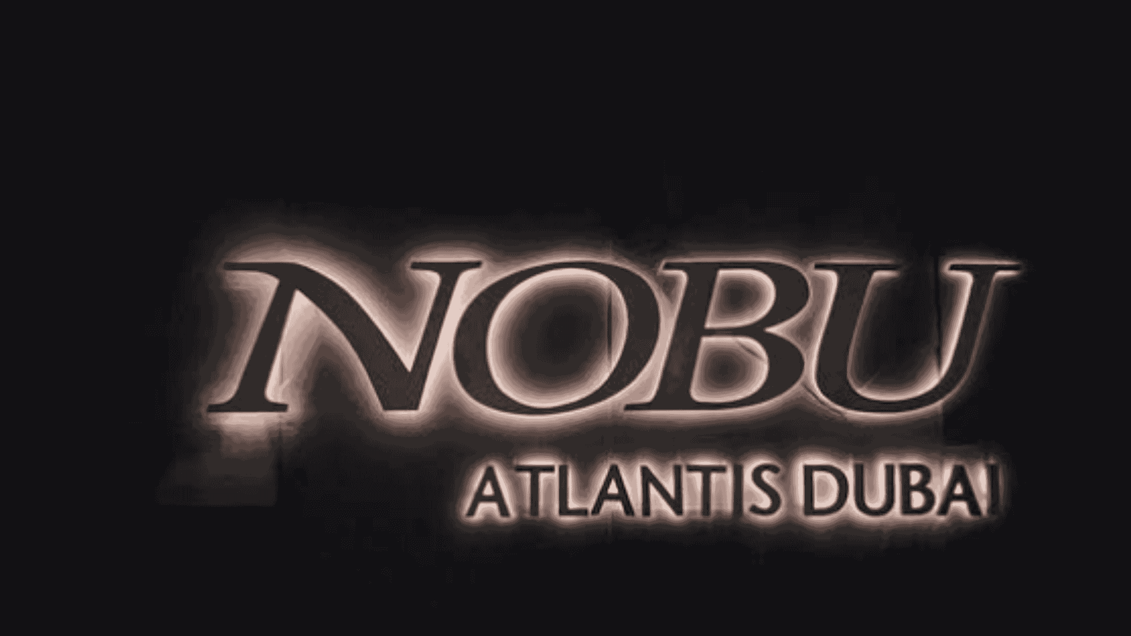 Illuminated Nobu Atlantis Dubai sign against a dark background